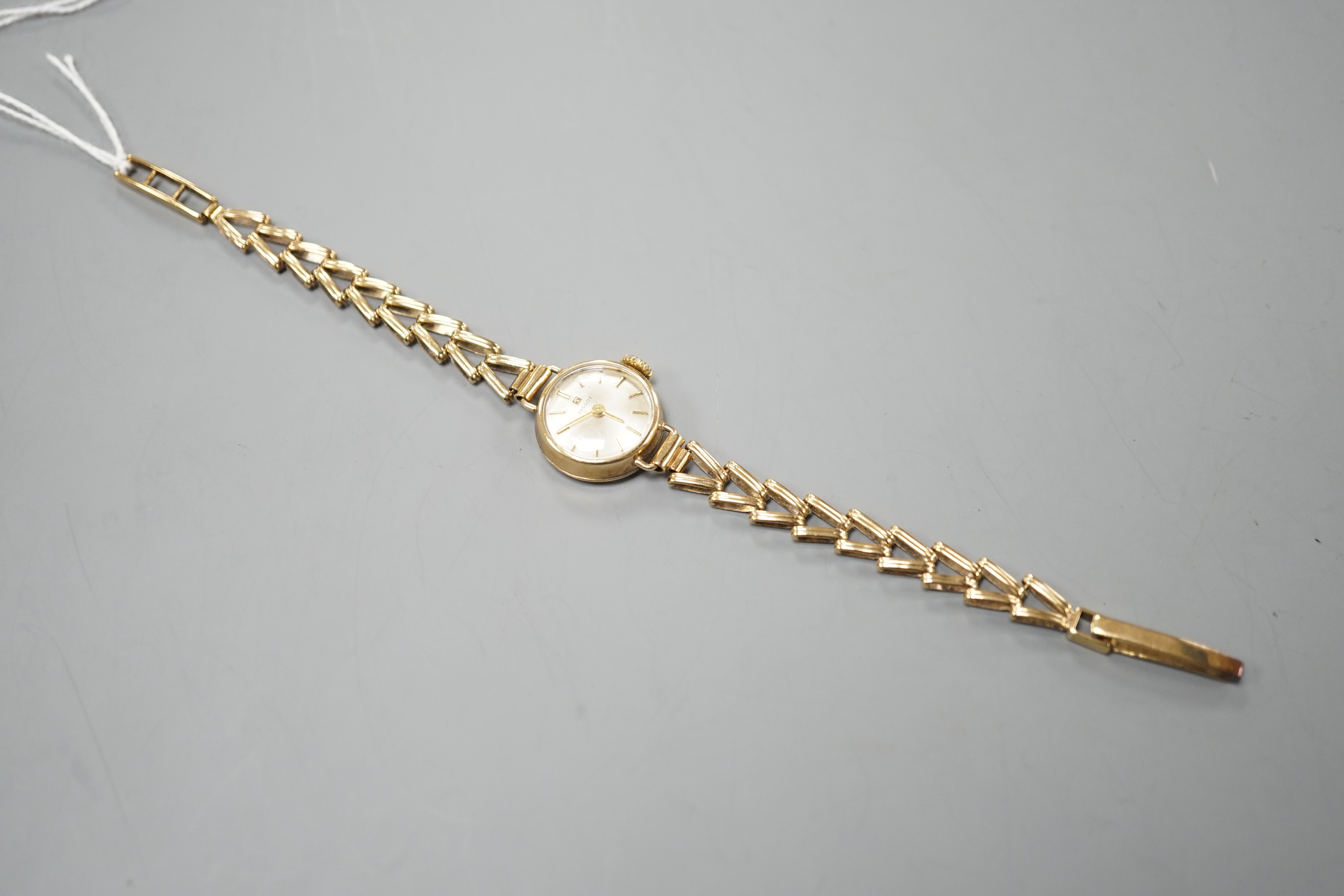 A lady's 9ct gold Tissot manual wind wrist watch, on a 9ct gold bracelet, overall length 16.25cm, gross weight 11.2 grams.